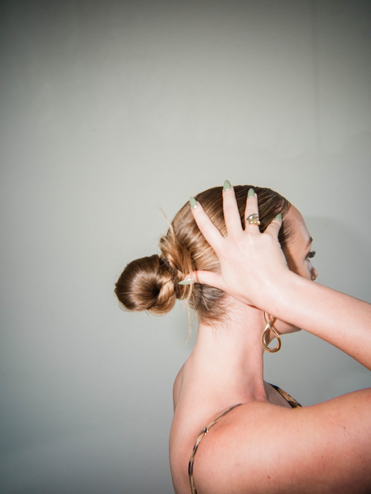 Woman holding her head, showing manicured nails after nail care in Columbus